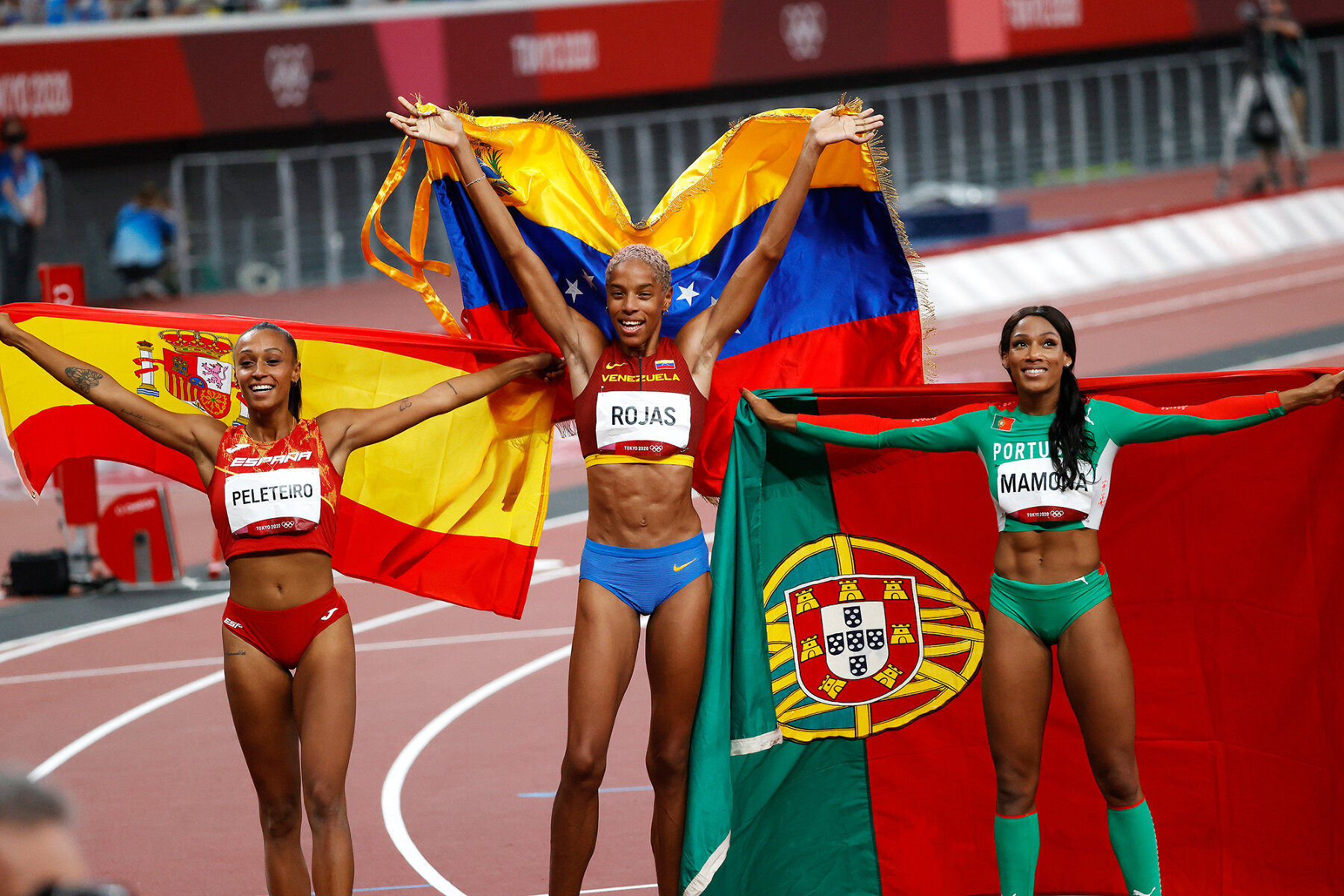 <p>Ана Пелетейро из Испании (бронза),&nbsp;Юлимар Рохас из Венесуэлы (золото) и&nbsp;Патрисия Мамона из Португалии (серебро)&nbsp;празднуют взятие пьедестала в тройном прыжке, 1 августа 2021 года</p>