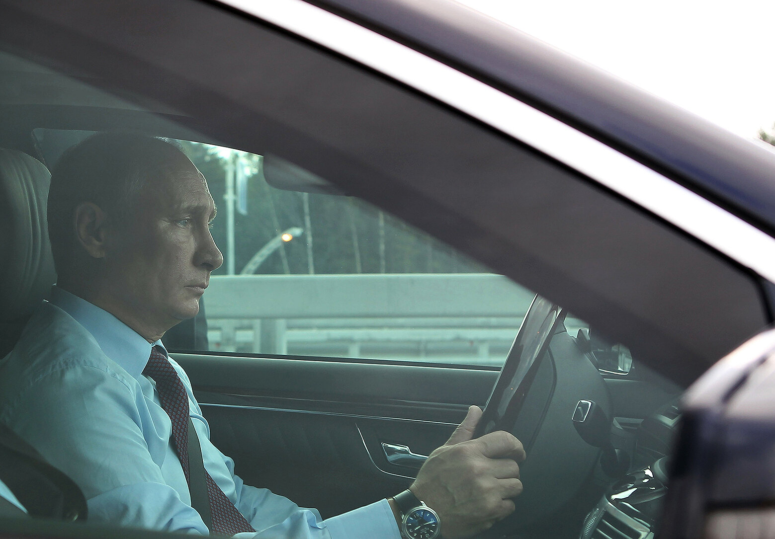 <p>Владимир Путин за рулем автомобиля перед торжественной церемонией запуска рабочего движения по северному участку Западного скоростного диаметра (ЗСД) в Санкт-Петербурге 2 августа 2013 года.</p>
